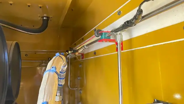 Stainless line and fittings along a compartment wall